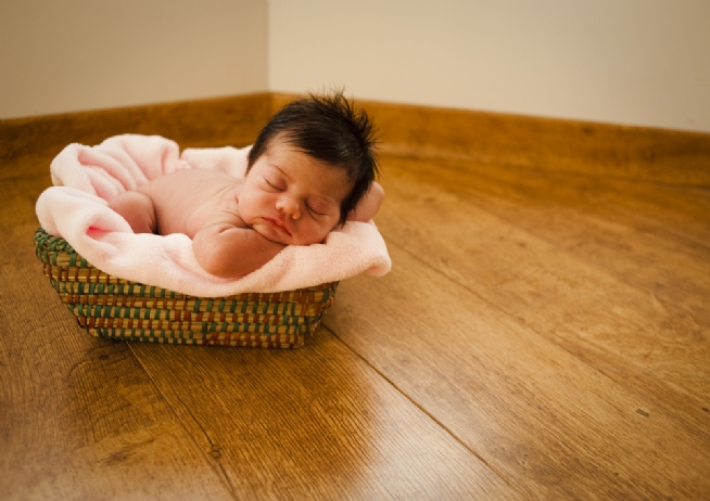 Sweet baby sleeping on a basket with a blanket